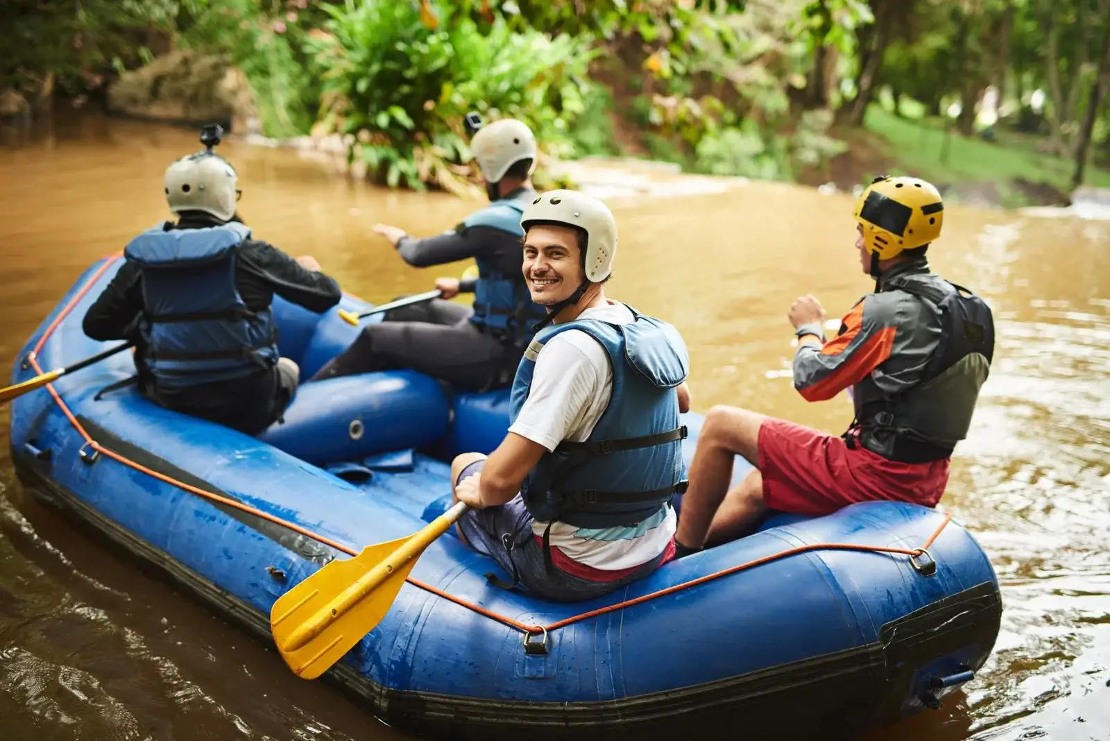 Group rafting on a river with safety gear