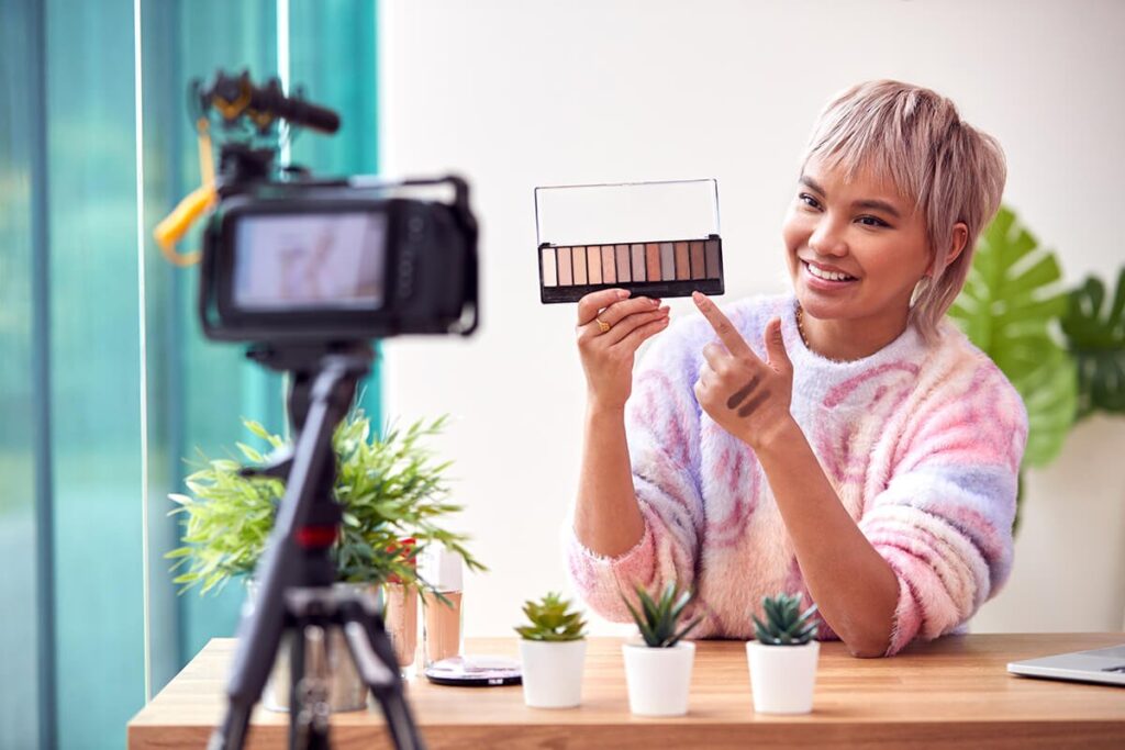 Female vlogger recording a makeup tutorial with an eyeshadow palette